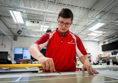 Young man at work in a signage facility