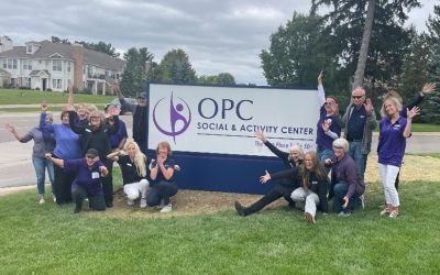 Group photo in front of the Old Person's Commission road sign in Rochester, MI