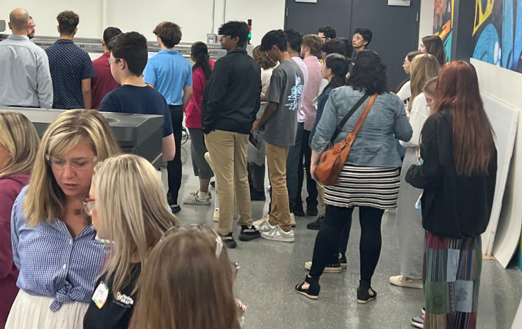 Group of high school students in a signage production warehouse