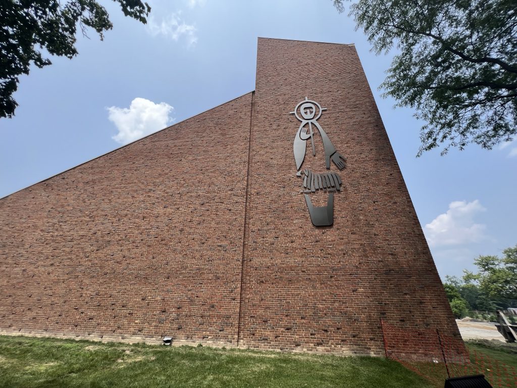 Silhouette signage of Jesus Christ on the side of a brick church