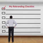 Man standing in front of life-sized checklist that is titled My Rebranding Checklist